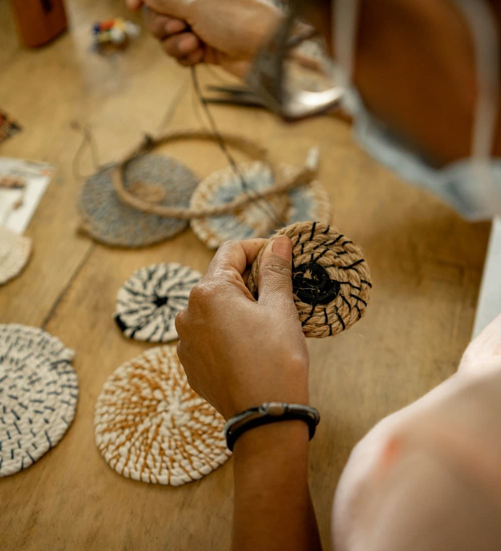 An Earthly Elegance artisan hand-stitching a natural-fiber piece